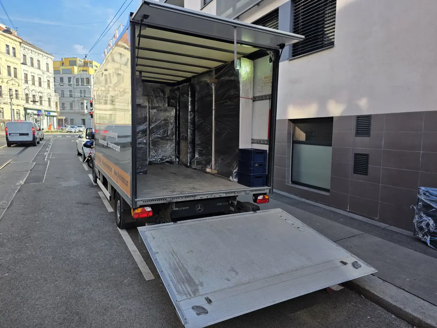 FlexiTrans truck with tail lift during a move in Vienna