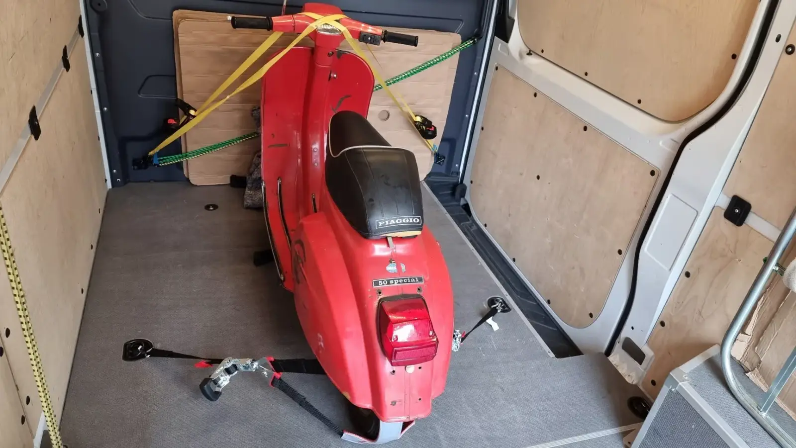Roter Motoroller gesichert in einem Transporter
